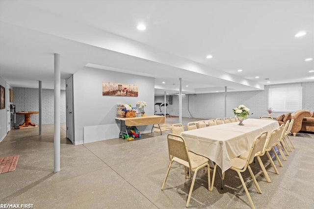 dining area featuring recessed lighting and brick wall