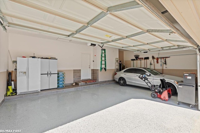 garage with white refrigerator with ice dispenser and a garage door opener