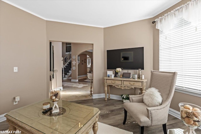 interior space featuring ornamental molding, wood finished floors, stairway, arched walkways, and baseboards