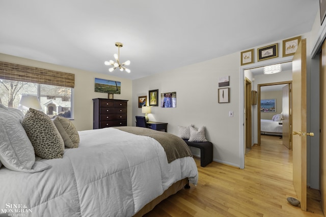 bedroom featuring a chandelier, baseboards, and light wood-style flooring