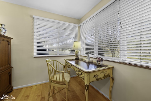 home office with baseboards and light wood finished floors