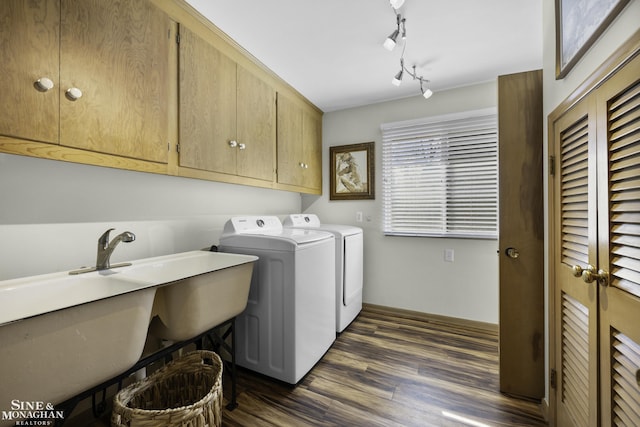 washroom with track lighting, dark wood-style floors, cabinet space, and washer and clothes dryer