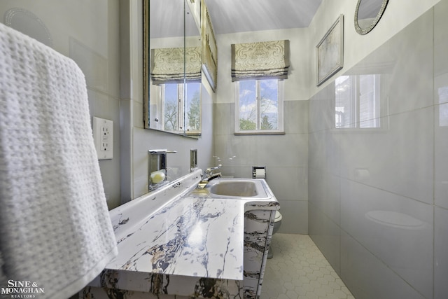 bathroom featuring toilet, tile walls, and vanity