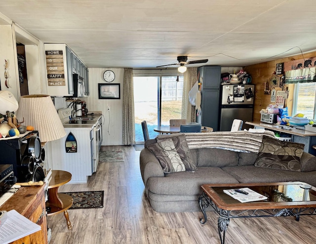 living room featuring a wealth of natural light, light wood-type flooring, and ceiling fan