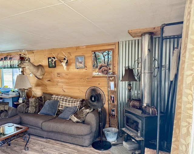 living area featuring wood finished floors, a wood stove, and wood walls