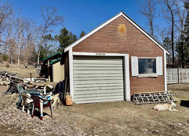 garage featuring driveway and fence