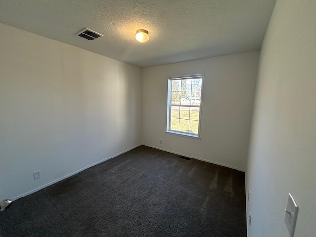 empty room featuring visible vents, a textured ceiling, baseboards, and dark colored carpet