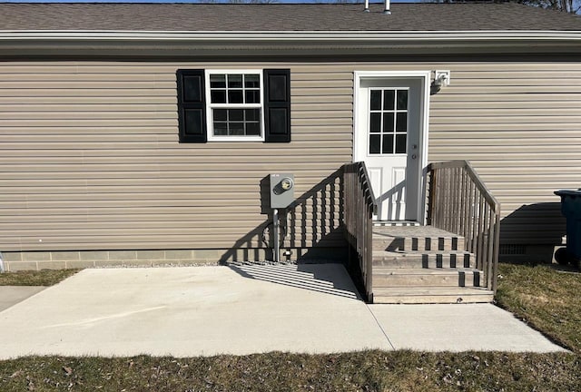 doorway to property with a patio area, roof with shingles, and crawl space