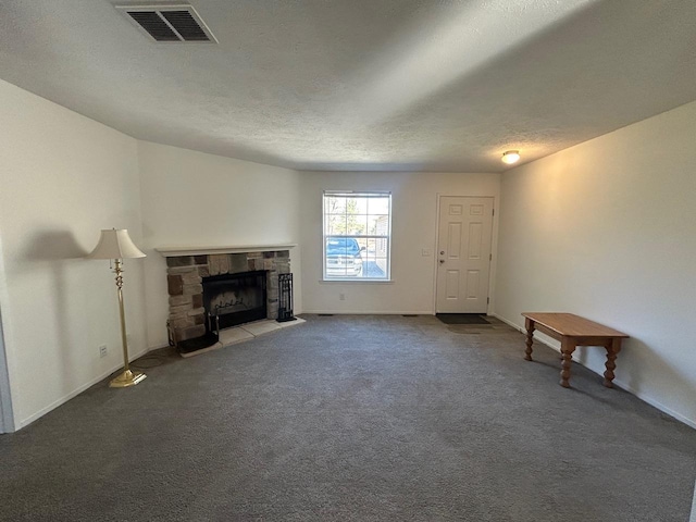 unfurnished living room with baseboards, visible vents, carpet floors, a fireplace, and a textured ceiling