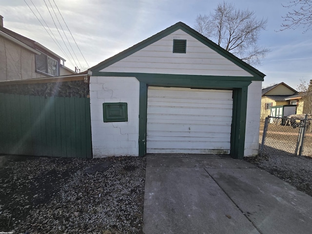 garage with driveway and fence