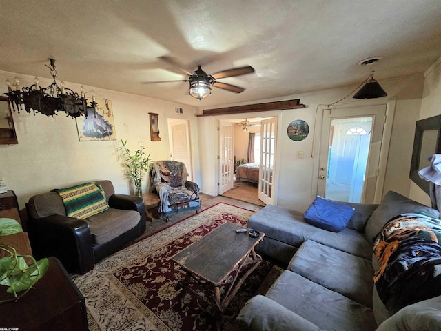 living area featuring visible vents, french doors, and ornamental molding