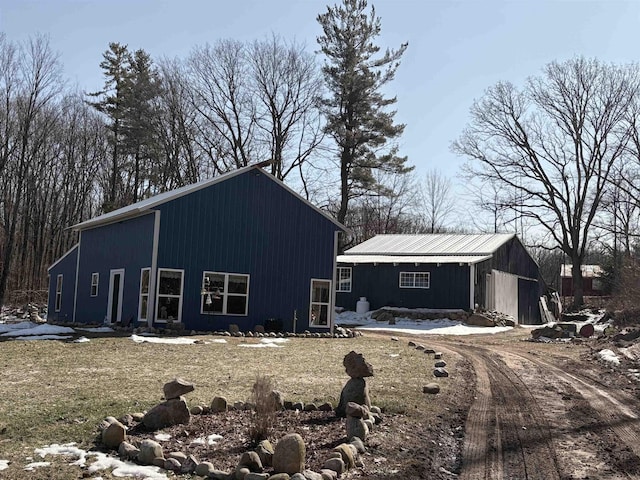 view of front facade featuring an outbuilding and dirt driveway