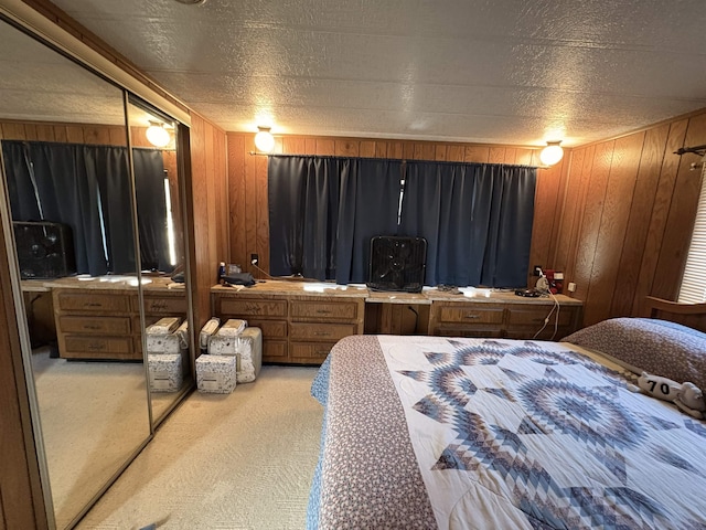 carpeted bedroom with wooden walls and a textured ceiling