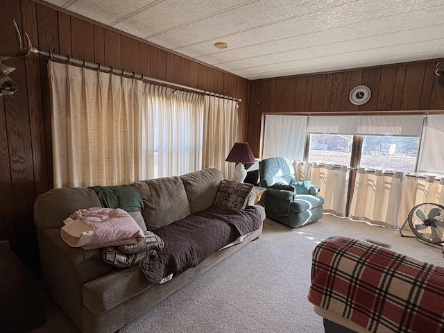 living area with plenty of natural light, wooden walls, and carpet floors