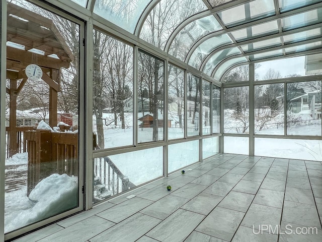 unfurnished sunroom featuring lofted ceiling