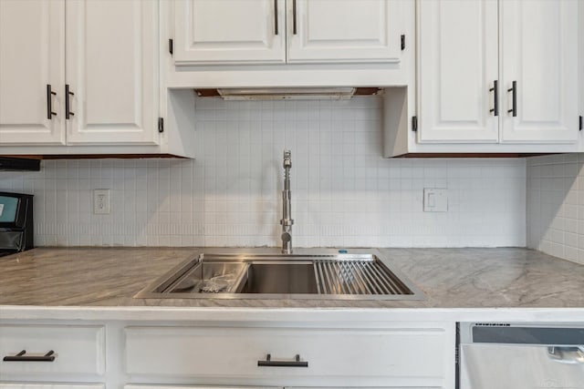 kitchen with a sink, dishwasher, white cabinets, and light countertops