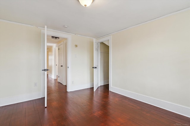 spare room featuring baseboards and wood finished floors