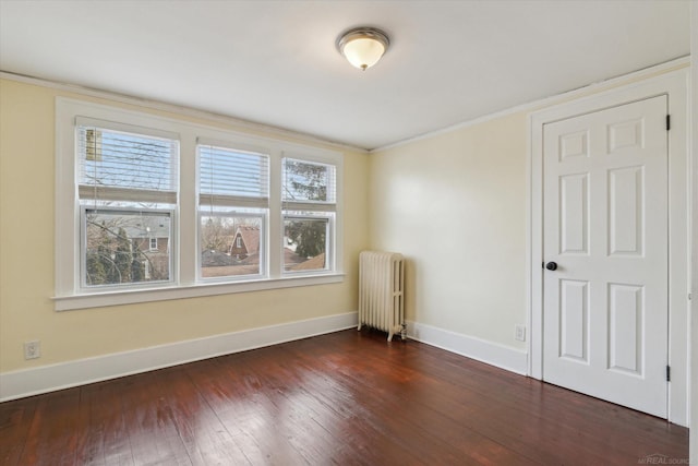 unfurnished room featuring dark wood-style floors, radiator, baseboards, and ornamental molding