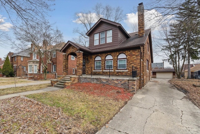 view of front facade with an outdoor structure, brick siding, and a chimney