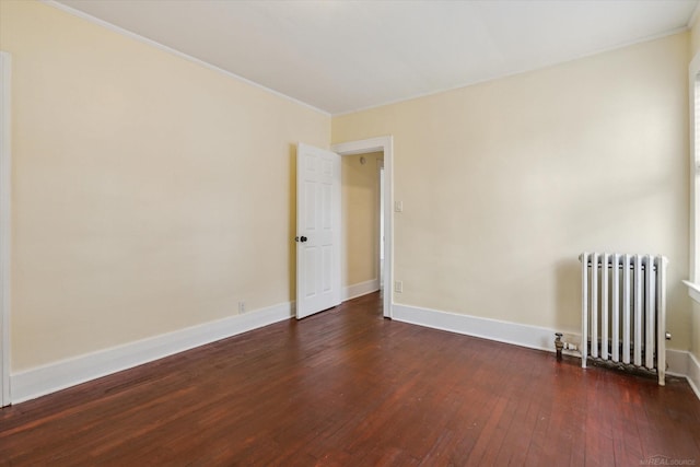 empty room with radiator, crown molding, baseboards, and hardwood / wood-style flooring