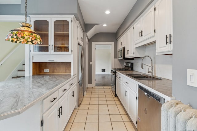 kitchen with glass insert cabinets, appliances with stainless steel finishes, light tile patterned flooring, white cabinets, and a sink