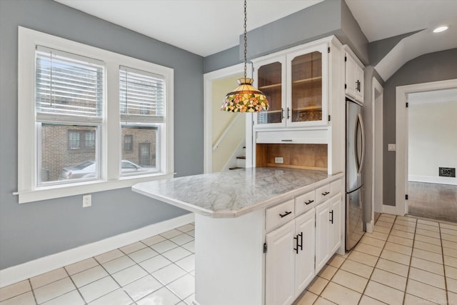 kitchen with a peninsula, white cabinets, light tile patterned floors, and glass insert cabinets