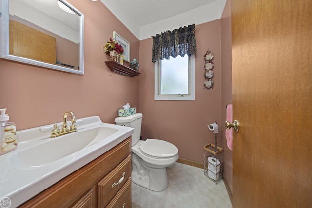 bathroom with baseboards, toilet, and vanity