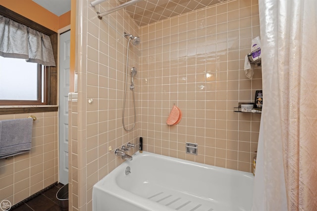 full bath with tile walls, shower / bath combo, and tile patterned flooring