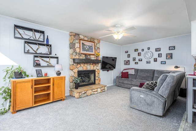 carpeted living room featuring a fireplace, crown molding, and ceiling fan