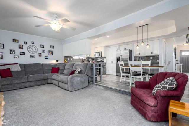 living room featuring a ceiling fan and ornamental molding