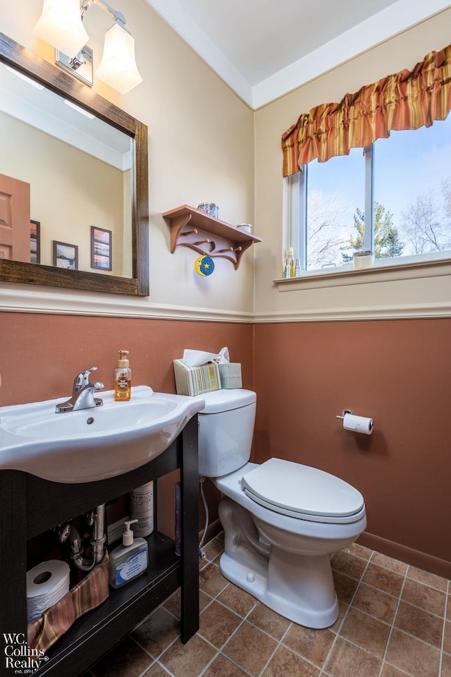 half bathroom with toilet and tile patterned flooring