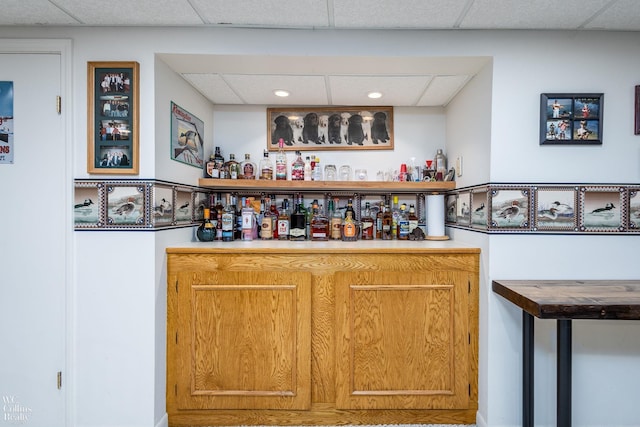 bar featuring a paneled ceiling and a bar