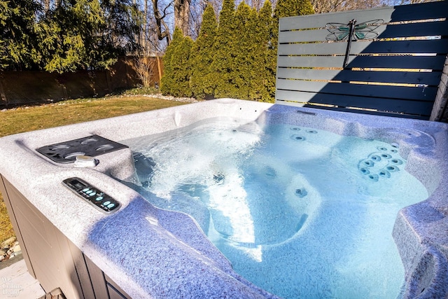 exterior details featuring a hot tub and fence