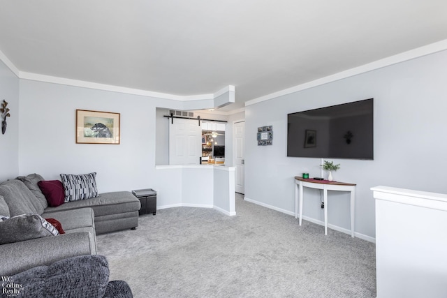 carpeted living area featuring a barn door, baseboards, and ornamental molding