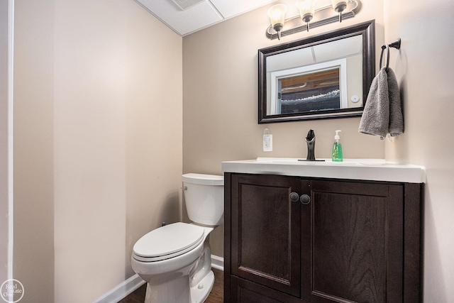 bathroom featuring vanity, toilet, and baseboards