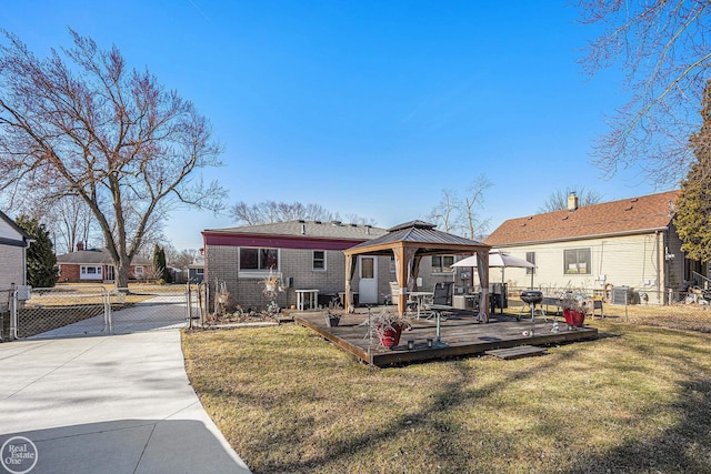 rear view of property with a gate, fence, a gazebo, concrete driveway, and a lawn