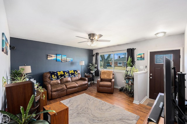 living room with baseboards, light wood-style floors, and a ceiling fan