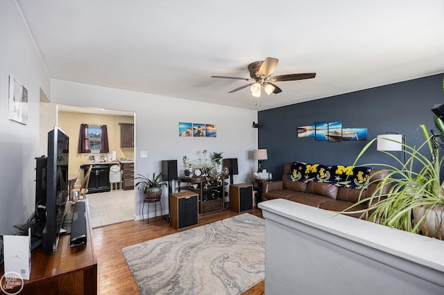 living room featuring a ceiling fan and wood finished floors