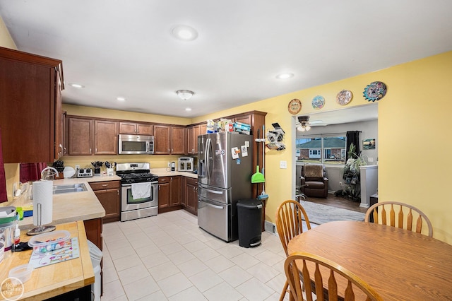 kitchen featuring light countertops, recessed lighting, appliances with stainless steel finishes, and a sink