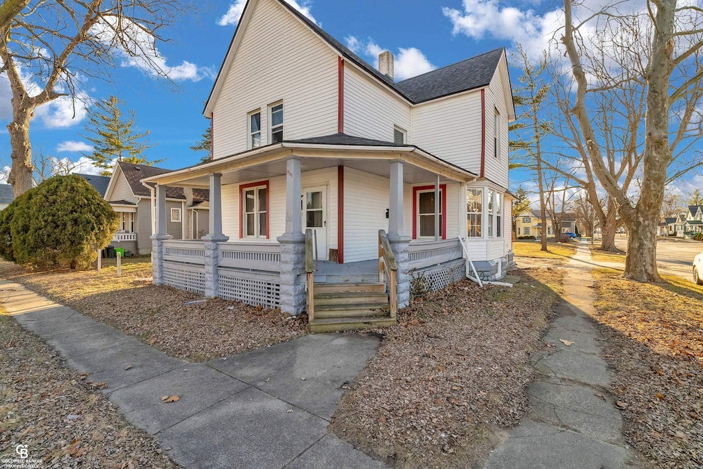 view of front of home featuring covered porch and a chimney