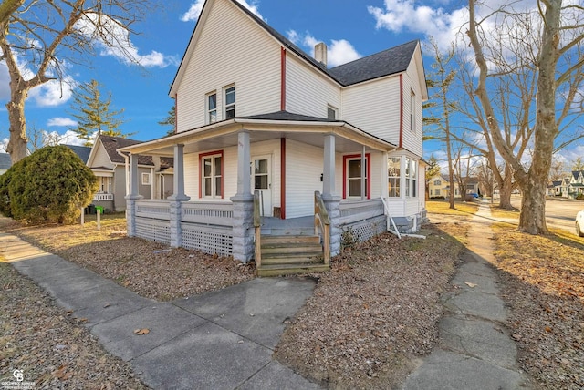 view of front of home featuring covered porch and a chimney