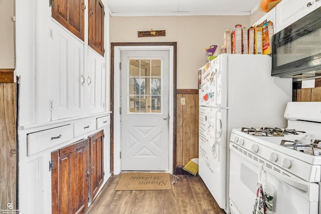 kitchen featuring ornamental molding, wood finished floors, black microwave, and white gas range oven