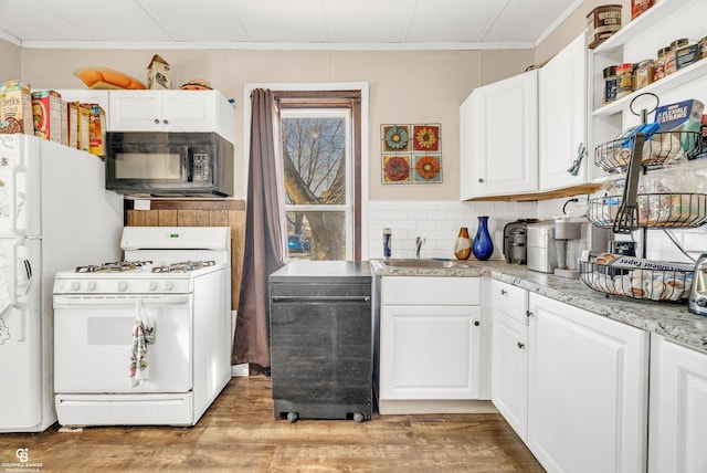 kitchen featuring a sink, light wood-type flooring, white appliances, and light countertops