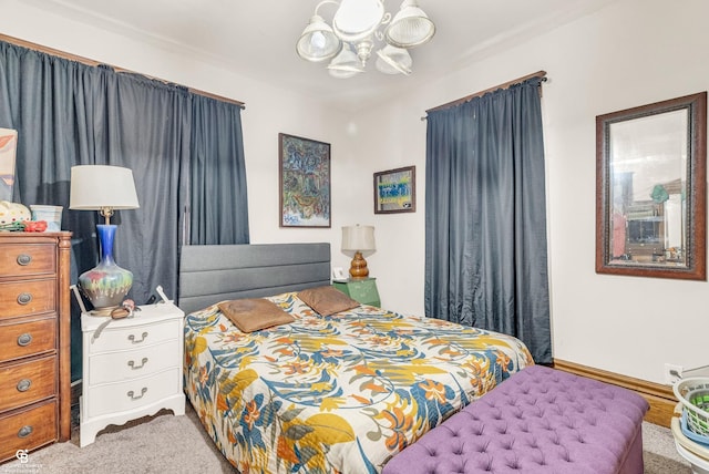 carpeted bedroom with a chandelier and baseboards