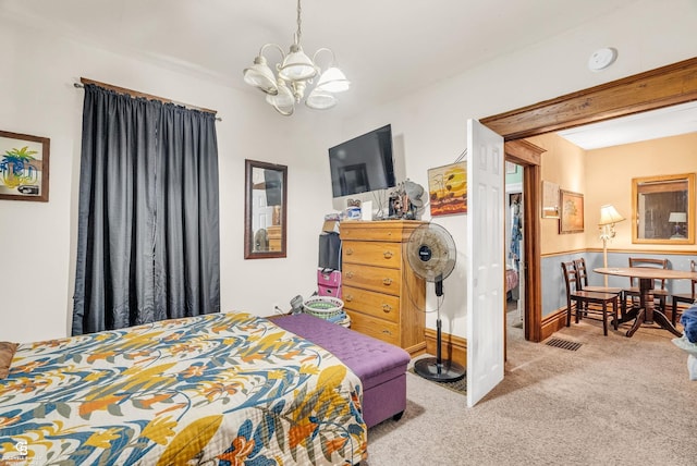 carpeted bedroom with an inviting chandelier