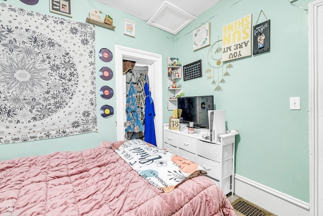 bedroom featuring baseboards and attic access