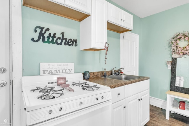 kitchen featuring a sink, wood finished floors, white cabinetry, baseboards, and white range with gas stovetop