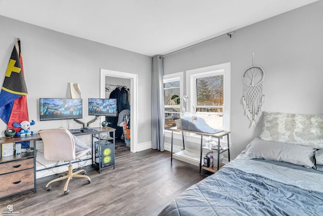 bedroom with a closet, baseboards, and wood finished floors