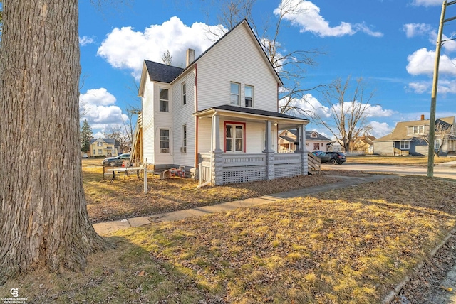 view of front of house with a residential view, covered porch, and a chimney