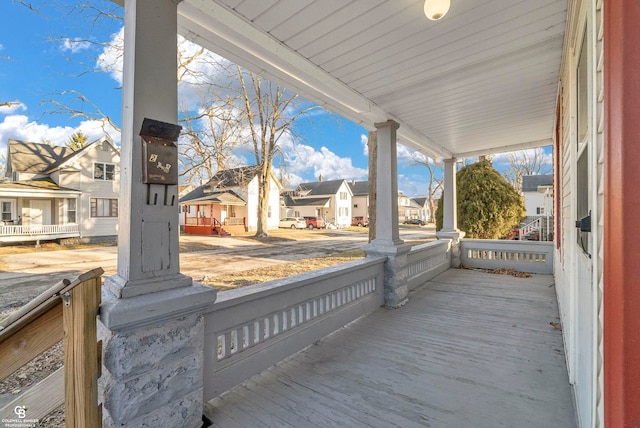 wooden deck featuring a residential view and covered porch